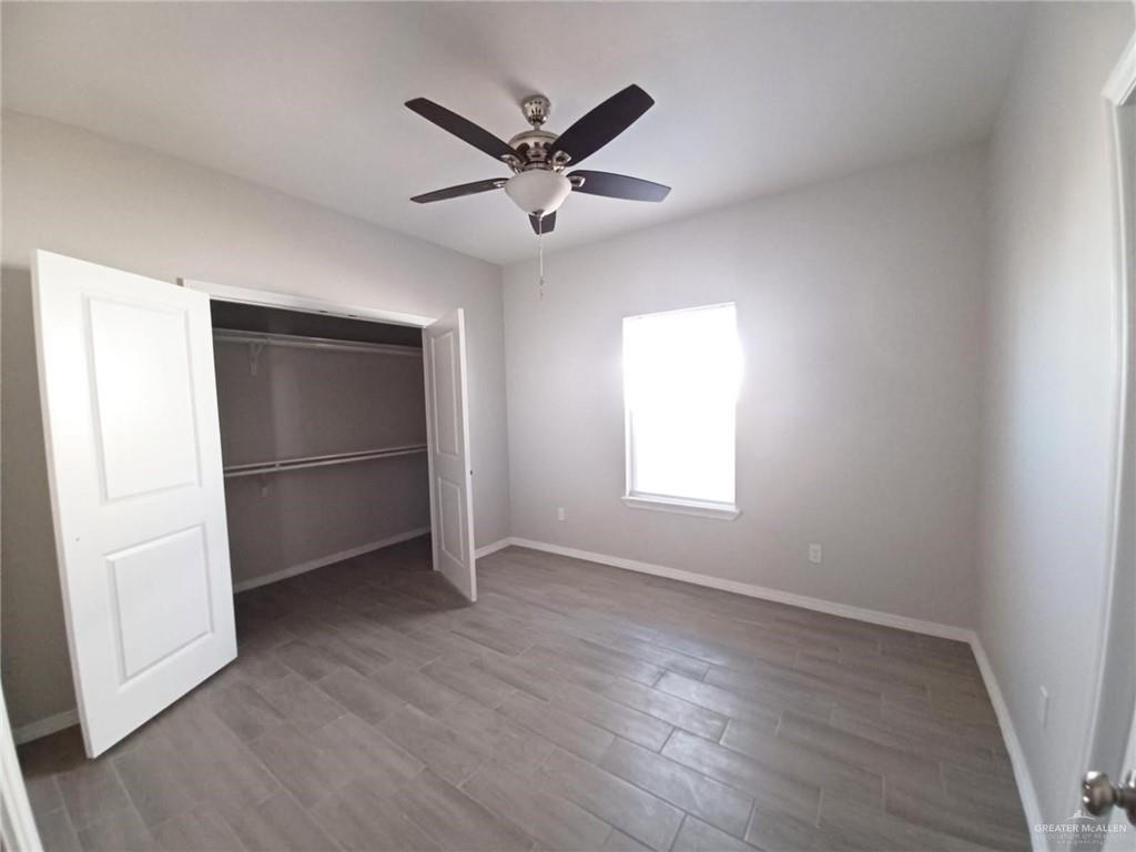 1506 Playa Drive, Unit 1 Weslaco, TX 78596 - Photo 5 of 9 wooden floor in an empty room with a window