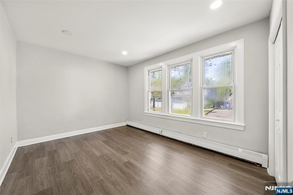 267 Hirliman Road Englewood, NJ 07631 - Photo 9 of 16 an empty room with wooden floor and windows