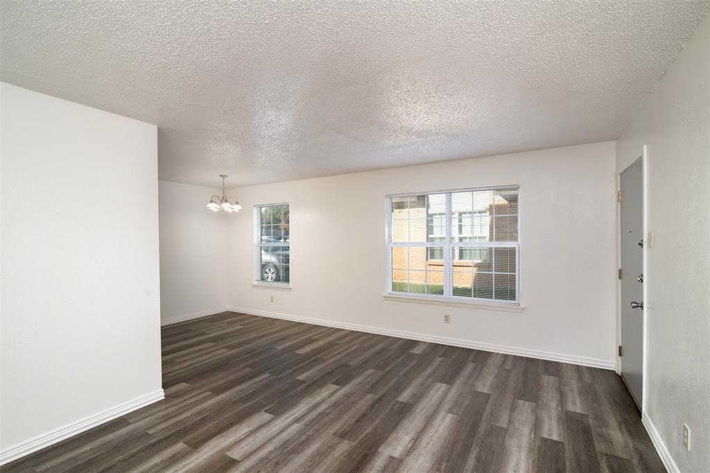 7064 Glenview Drive, Unit 92 North Richland Hills, TX 76180 - Photo 7 of 11 an empty room with wooden floor and windows