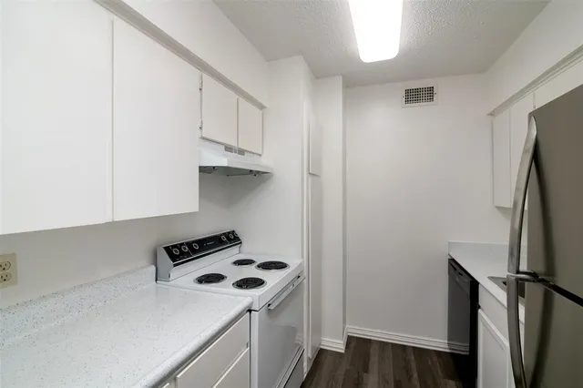 a kitchen with stainless steel appliances a refrigerator a stove and a more cabinets