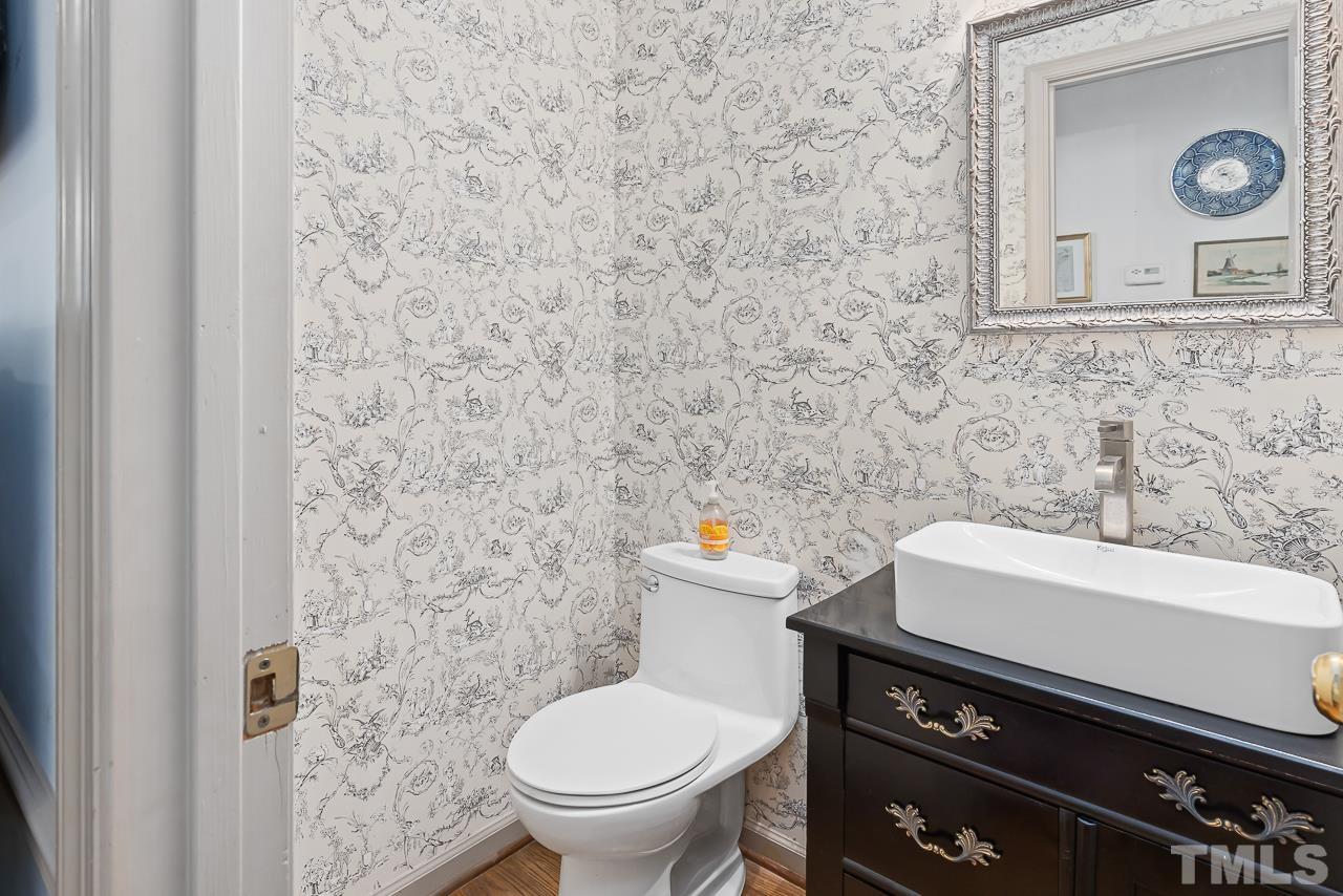 7309 Glendower Road Raleigh, NC 27613 - Photo 7 of 19 a bathroom with a toilet a sink and a mirror