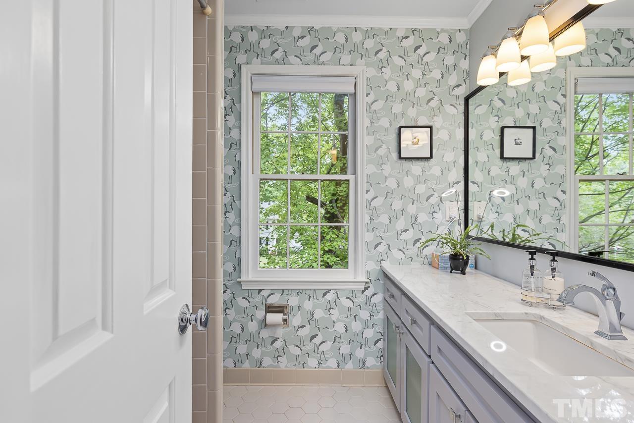 7309 Glendower Road Raleigh, NC 27613 - Photo 8 of 19 a bathroom with a granite countertop sink a mirror and a shower