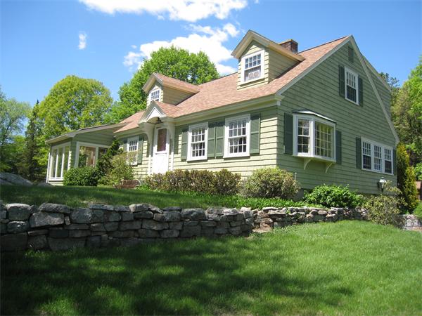 a front view of a house with a garden