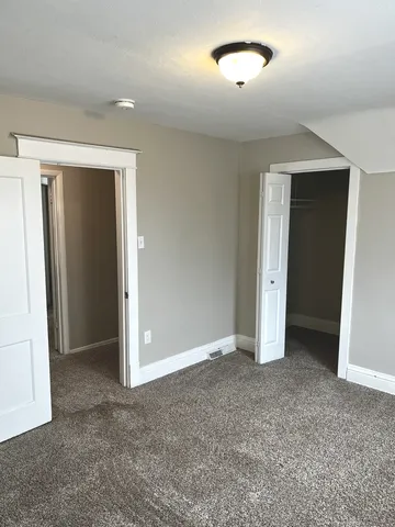 an empty room with closet and a bathroom