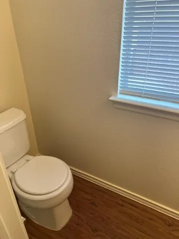 a white toilet sitting next to a small window