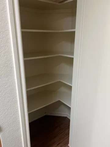 a view of walk in closet with empty racks