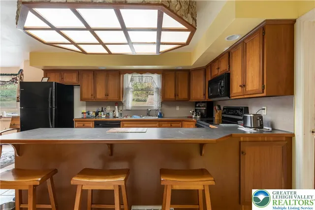 a kitchen with stainless steel appliances granite countertop a sink a stove a refrigerator and cabinets