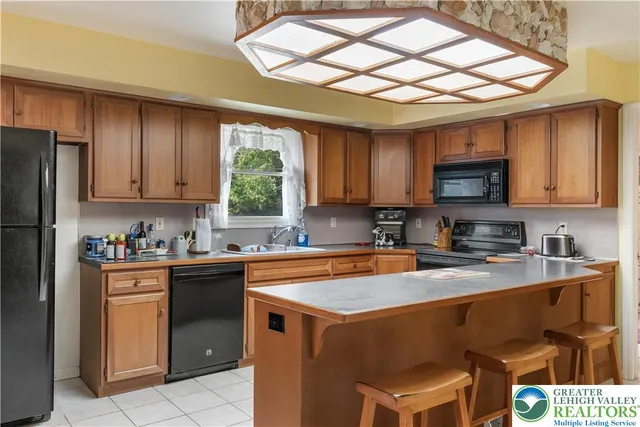 a kitchen with stainless steel appliances kitchen island granite countertop a refrigerator and microwave