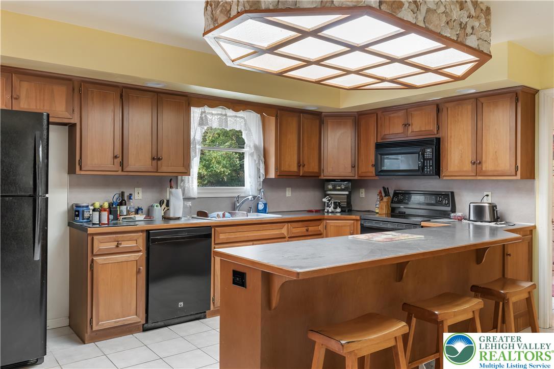 390 Long Lane Road Walnutport, PA 18088 - Photo 14 of 56 a kitchen with stainless steel appliances granite countertop a sink a stove a refrigerator and cabinets
