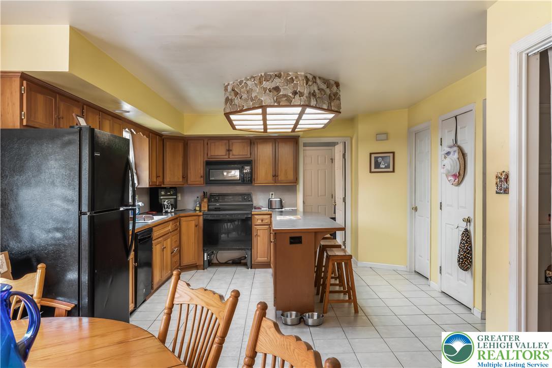 390 Long Lane Road Walnutport, PA 18088 - Photo 16 of 56 a kitchen with stainless steel appliances kitchen island granite countertop a refrigerator and microwave