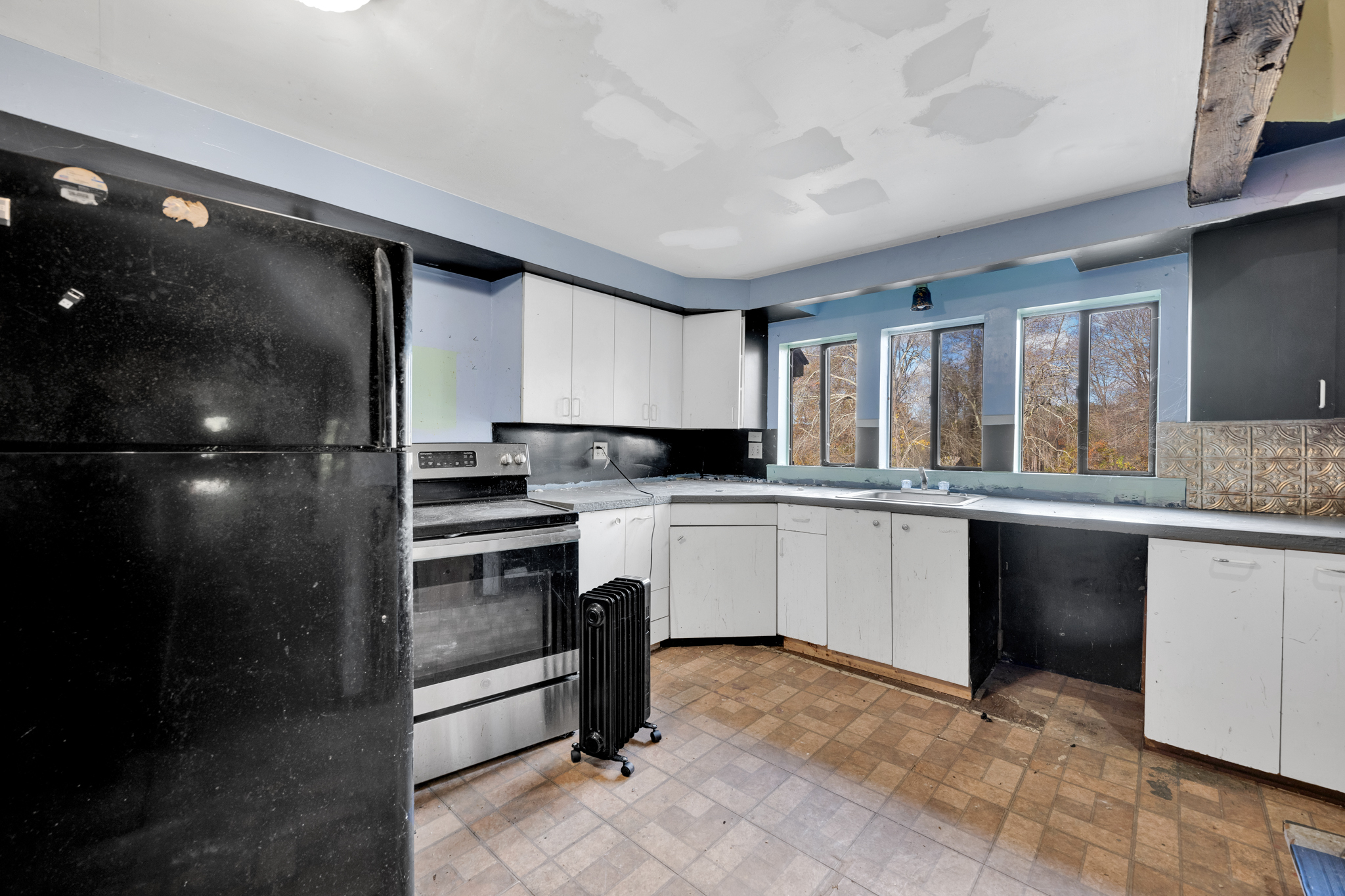 700 Bantam Road Litchfield, CT 06750 - Photo 26 of 40 a kitchen with granite countertop a refrigerator and white cabinets