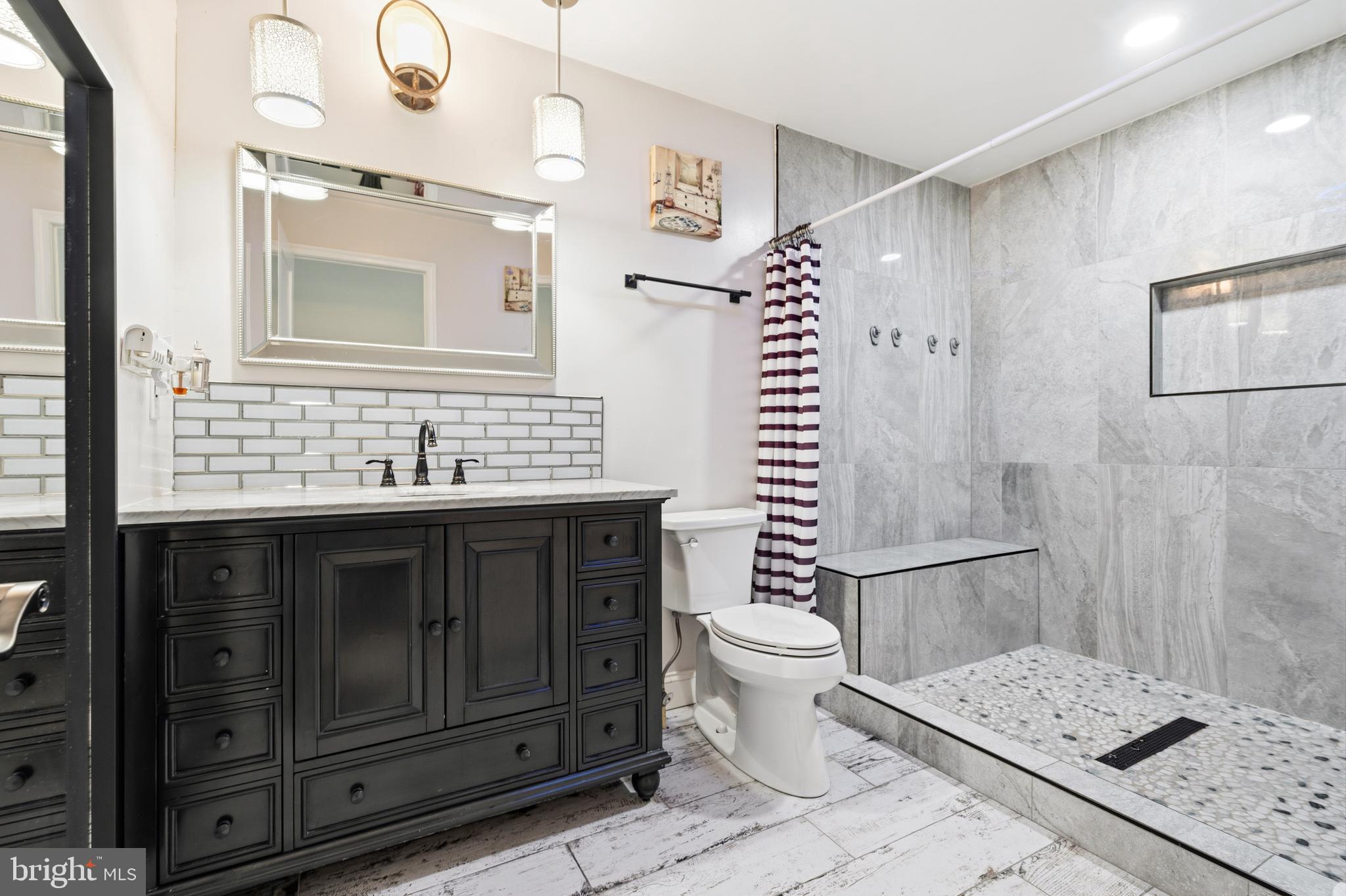 552 48th Street Baltimore, MD 21224 - Photo 15 of 29 a bathroom with a sink toilet a mirror and shower