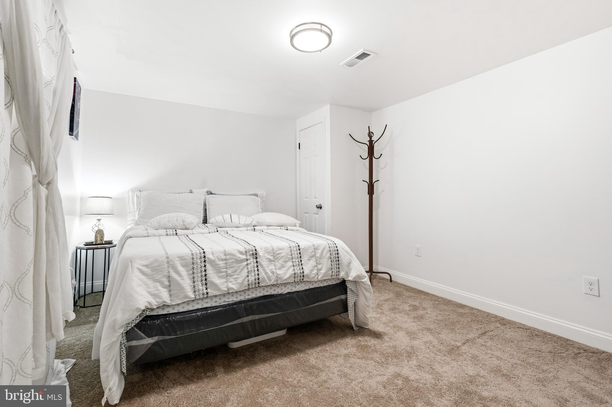552 48th Street Baltimore, MD 21224 - Photo 19 of 29 a spacious bedroom with a bed and a mirror