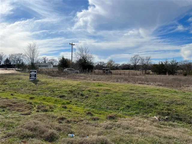 a view of a field with trees in the background