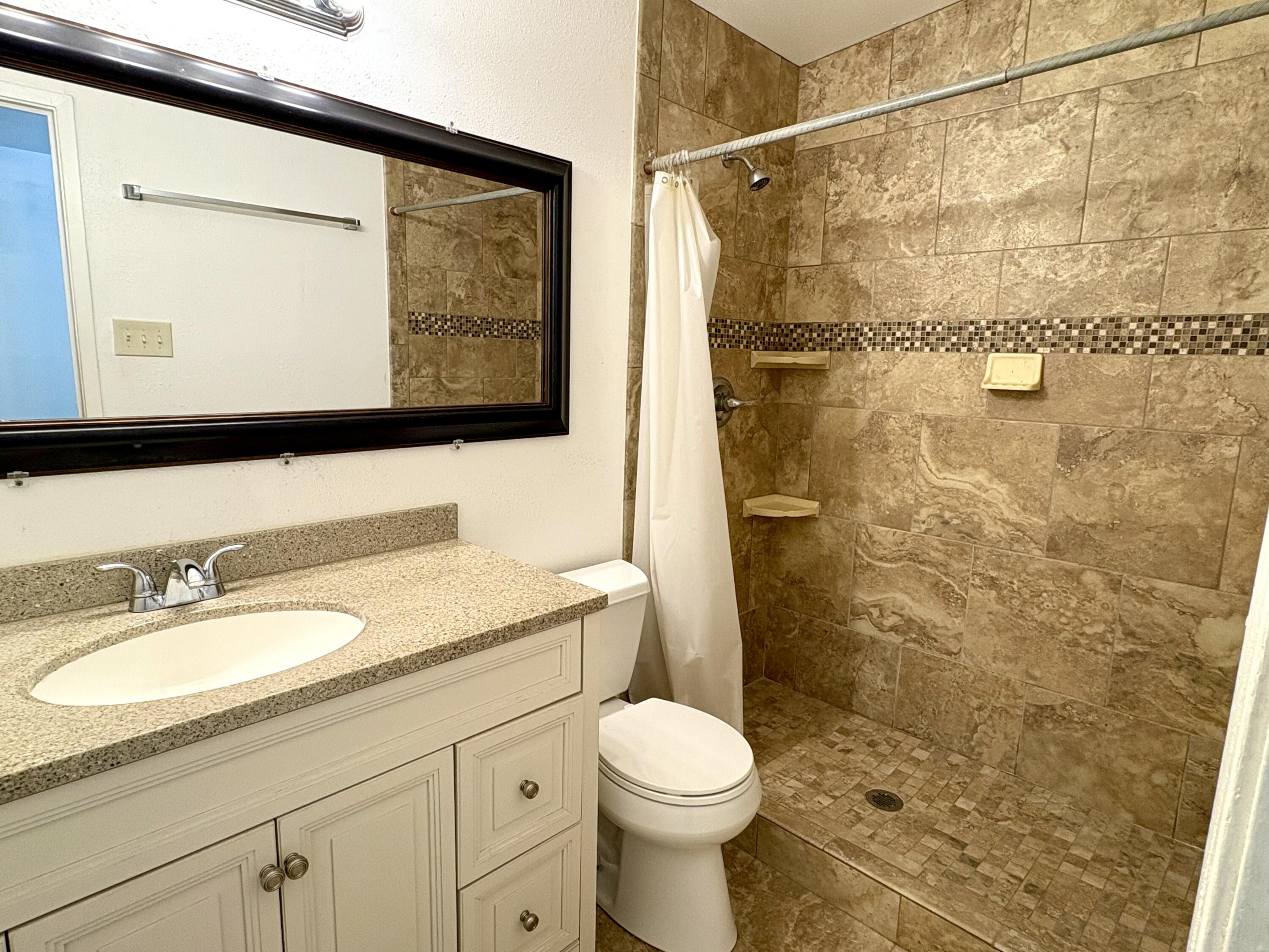 4618 44th Street Lubbock, TX 79414 - Photo 13 of 21 a bathroom with a granite countertop sink toilet and shower