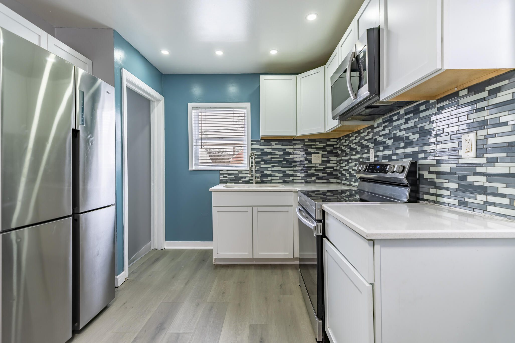 4601 Buchanan Street Gary, IN 46408 - Photo 10 of 27 a kitchen that has a sink stainless steel appliances a counter space and a window