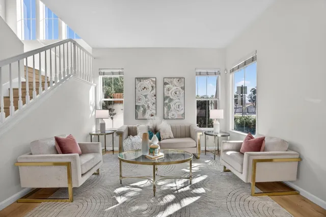 a living room with furniture wooden floor and wall paintings