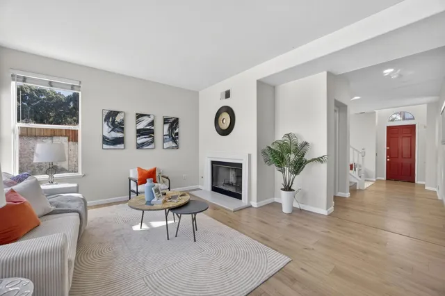 a living room with furniture a fireplace and a large window