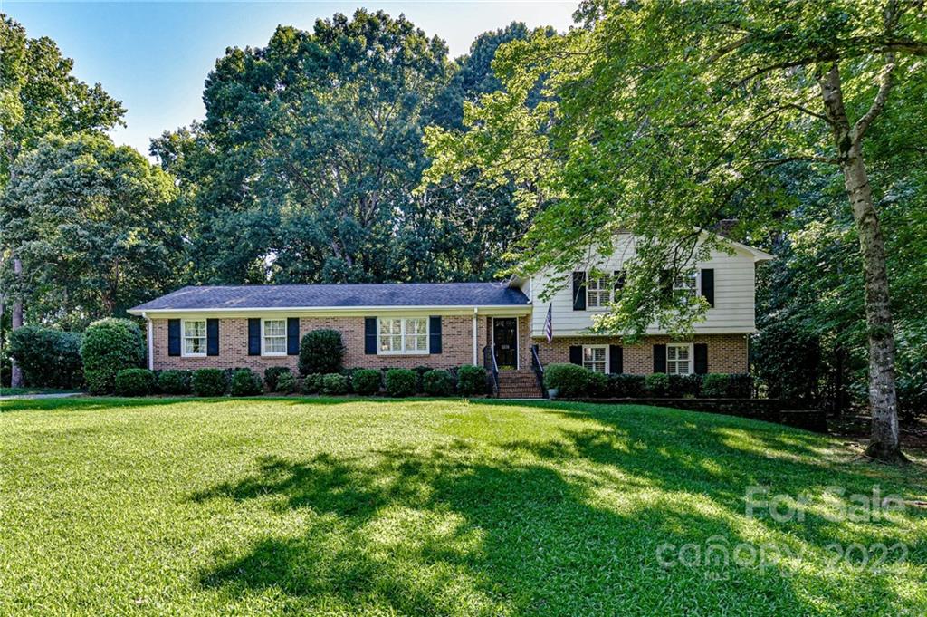1231 Reverdy Lane, Unit 32 Matthews, NC 28105 - Photo 1 of 39 a front view of a house with a garden and trees