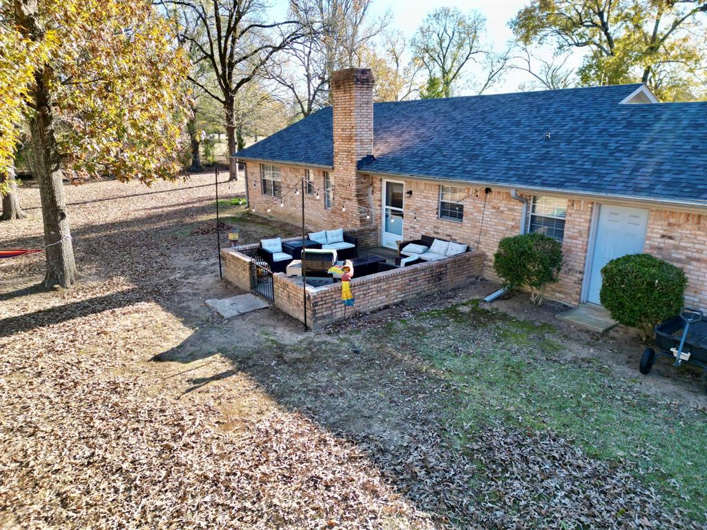 152 County Road Blossom, TX 75416 - Photo 17 of 21 a view of a backyard with table and chairs potted plants and a large tree
