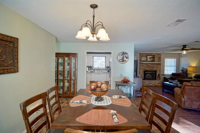 a view of a dining room with furniture a chandelier and wooden floor
