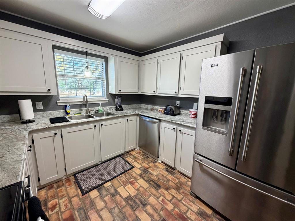 152 County Road Blossom, TX 75416 - Photo 8 of 21 a kitchen with white cabinets and white appliances