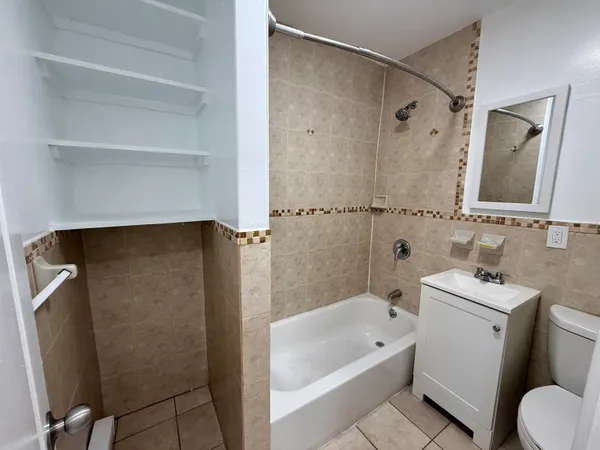 a bathroom with a bathtub shower sink vanity and toilet