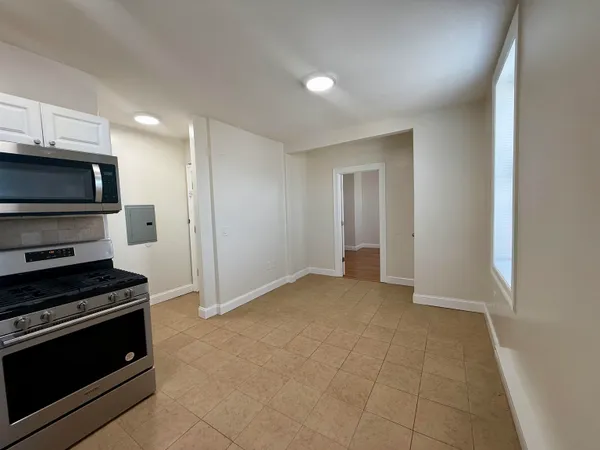a view of kitchen with a sink stove and cabinets