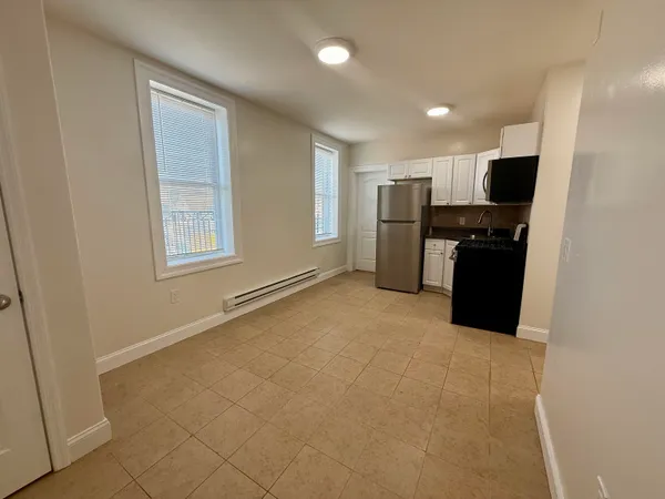 a view of a kitchen with refrigerator stove and wooden cabinets
