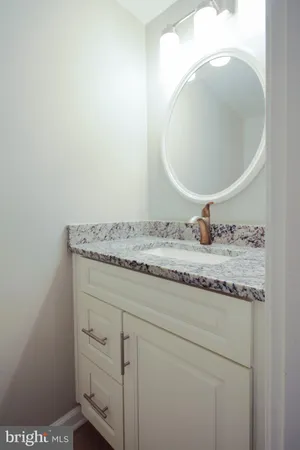 a bathroom with a granite countertop sink and mirror