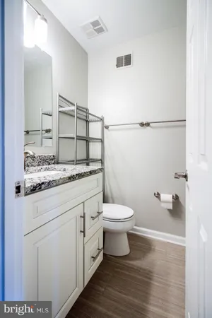 a bathroom with a granite countertop toilet sink and mirror