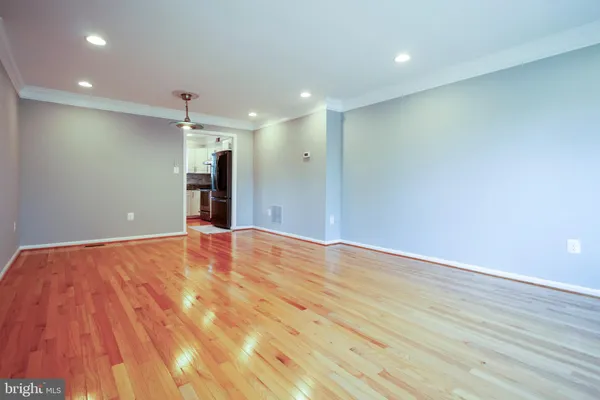 an empty room with wooden floor and a ceiling fan