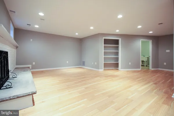 a view of an empty room with a fireplace and a window
