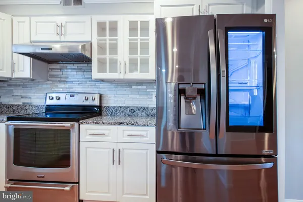 a kitchen with stainless steel appliances granite countertop a refrigerator and a stove