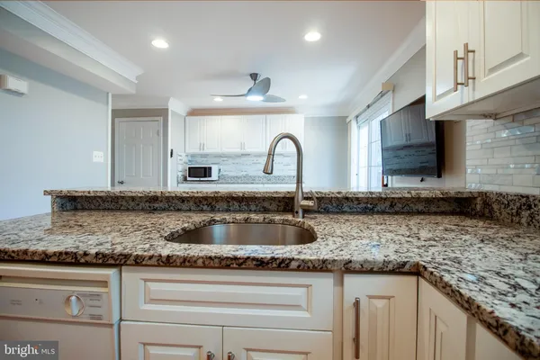 a kitchen with granite countertop a sink stainless steel appliances and cabinets