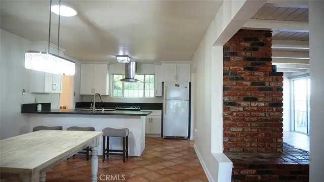 a kitchen with granite countertop a stove a sink and a refrigerator