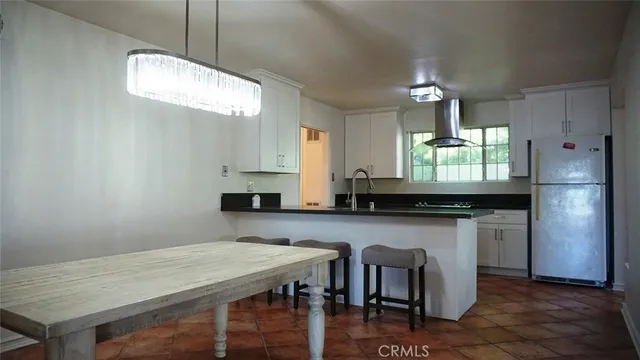 a kitchen with kitchen island a wooden floor and white cabinets