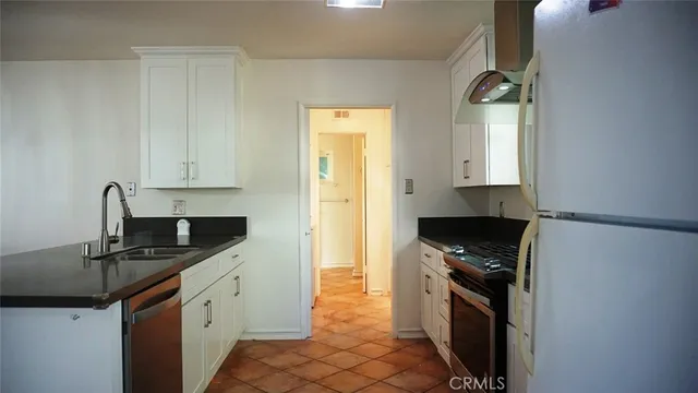 a kitchen with a stove a sink and a window