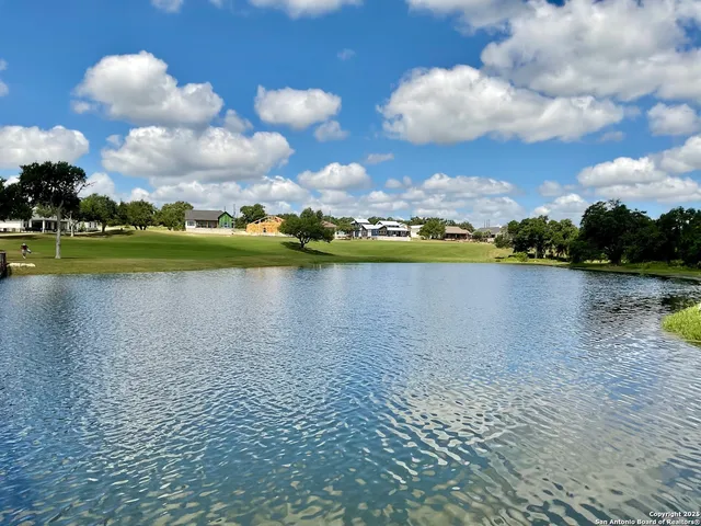 a view of a lake with houses in back