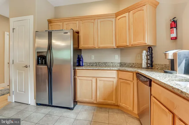 a kitchen with stainless steel appliances granite countertop a refrigerator and cabinets