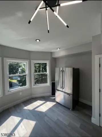 a view of empty room with a window and wooden floor