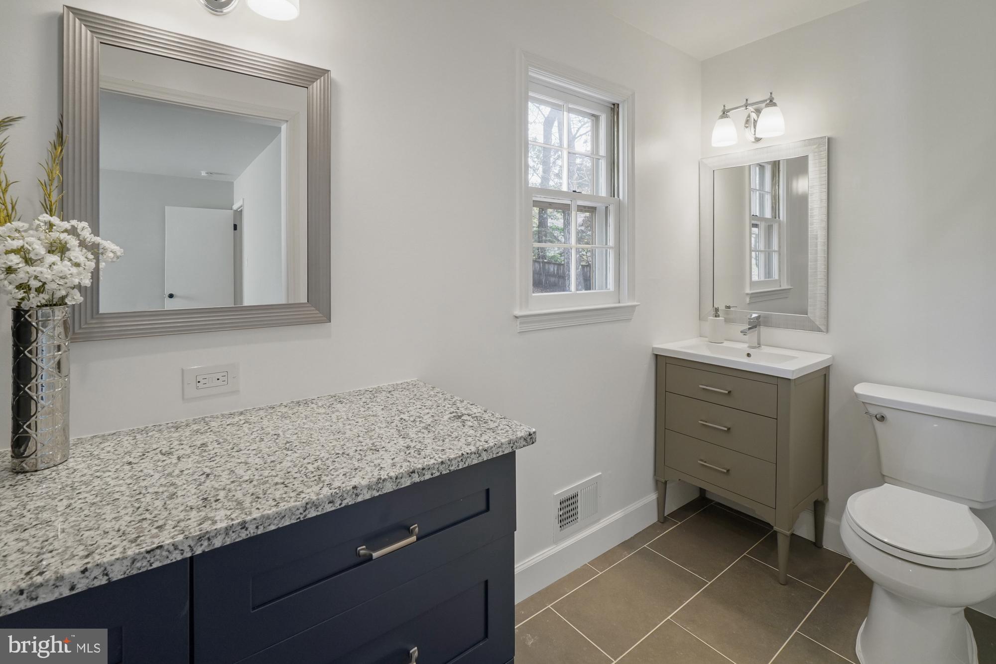 12539 Heurich Road Silver Spring, MD 20902 - Photo 22 of 46 a bathroom with a granite countertop sink a toilet and mirror