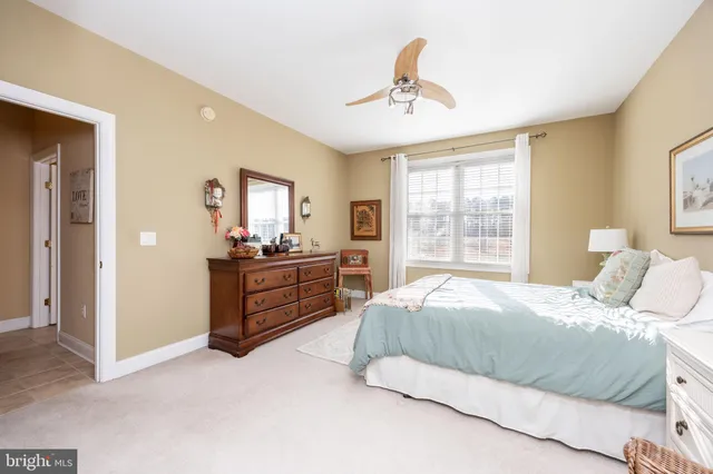 a spacious bedroom with a bed and ceiling fan