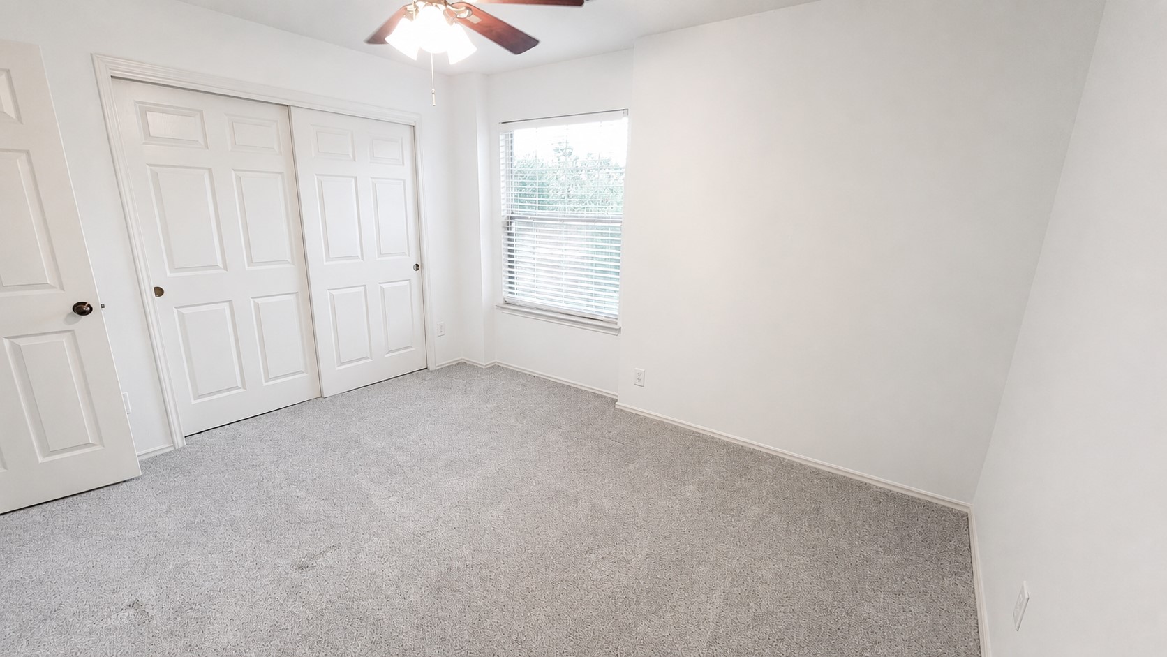 10528 Dunham Forest Road Austin, TX 78717 - Photo 10 of 12 A well-lit bedroom features plush carpeting, a single window, and a convenient closet with sliding doors.