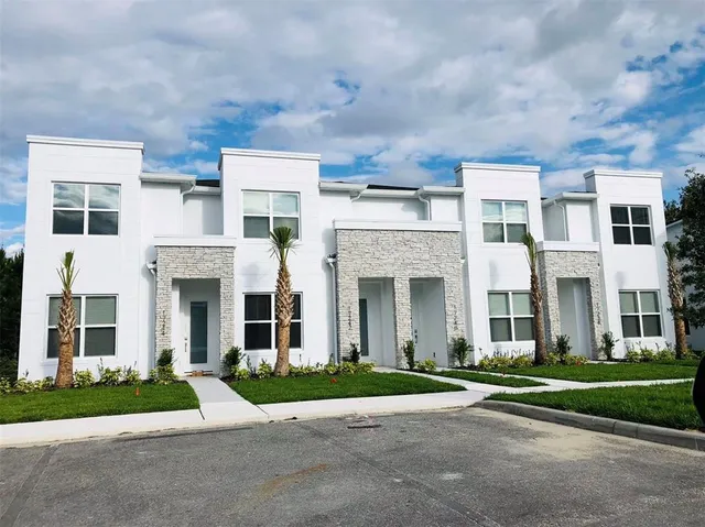 a front view of a brick house with a yard and large windows