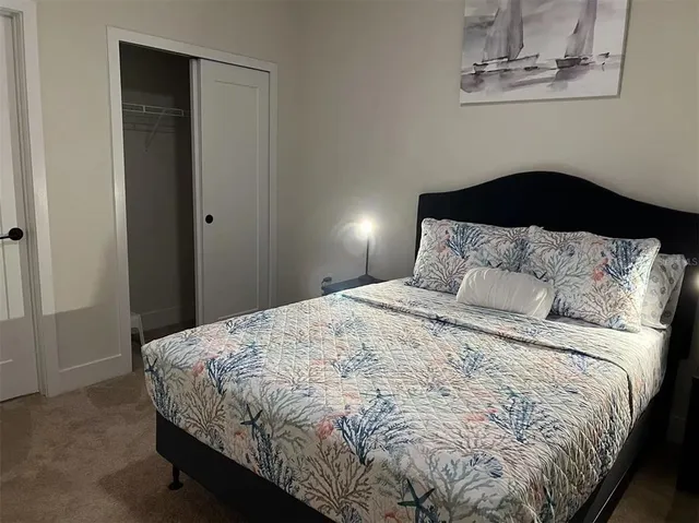 a bedroom with a bed and a painting on the wall