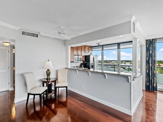 a kitchen with stainless steel appliances a table and chairs in it