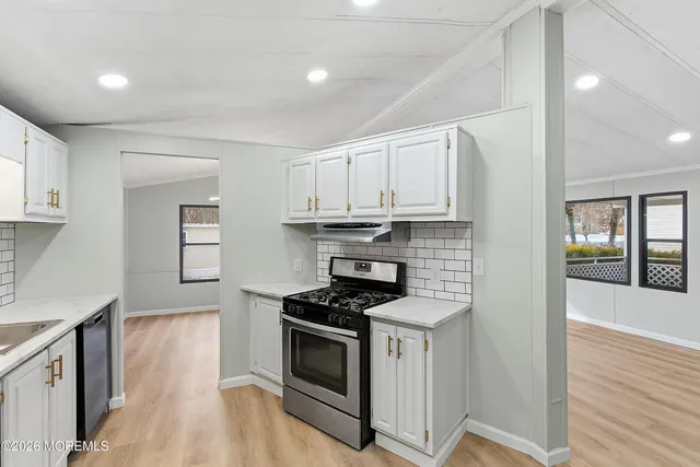 a kitchen with stainless steel appliances a sink stove and cabinets