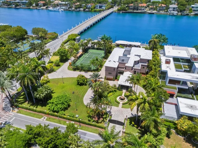 an aerial view of residential houses with outdoor space and lake view