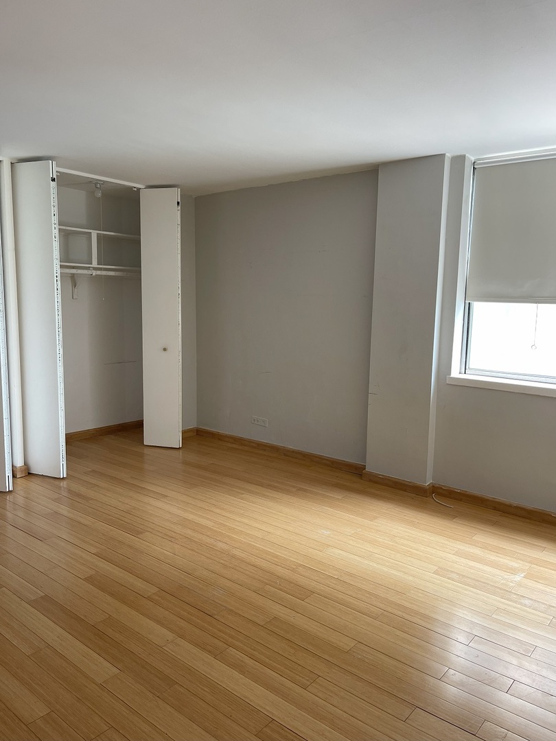 6301 North Sheridan Road, Unit 22F Chicago, IL 60660 - Photo 8 of 11 an empty room with wooden floor and windows